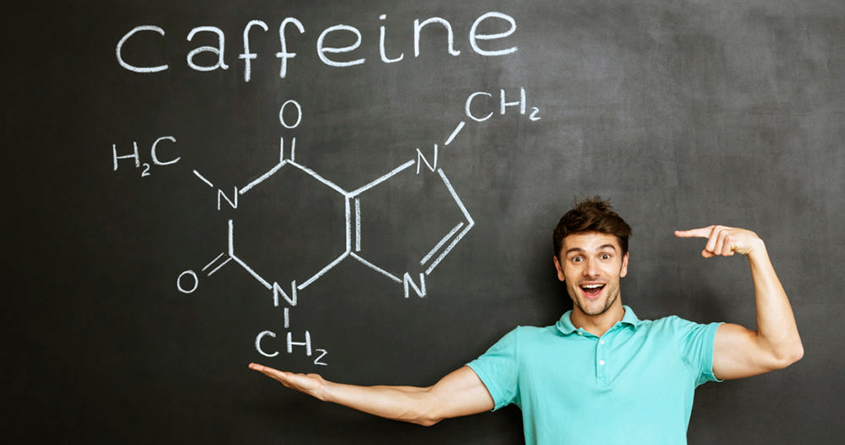 En mann står foran en tavler og viser frem den kjemiske formelen til koffein.