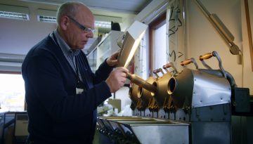 En mann står foran en espressomaskin og lager kaffe