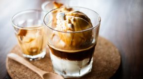 Et glass med affogato; iskrem med kaffe som saus. Ved siden av ligger det en skje.