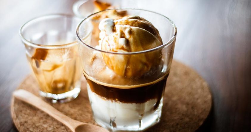 Et glass med affogato; iskrem med kaffe som saus. Ved siden av ligger det en skje.