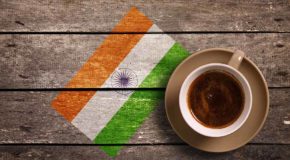 En bordoverflate av tre. Det indiske flagget er malt på bordet. En kopp kaffe står på bordet.