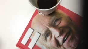 Et =Oslo-magasin og en kopp med kaffe.