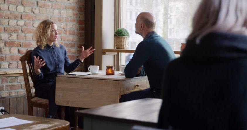Et skjermbilde fra miniepisoden om kaffebaren viser en mann og en kvinne som sitter på en kaffebar
