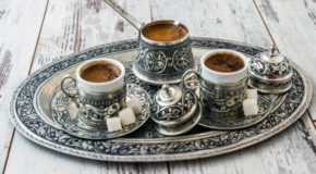 En tradisjonell tyrkisk kaffekanne og to kopper står på et serveringsfat i sølv