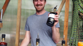 Tom Read viser frem en flaske med Kalkar Cornish Coffee Rum.
