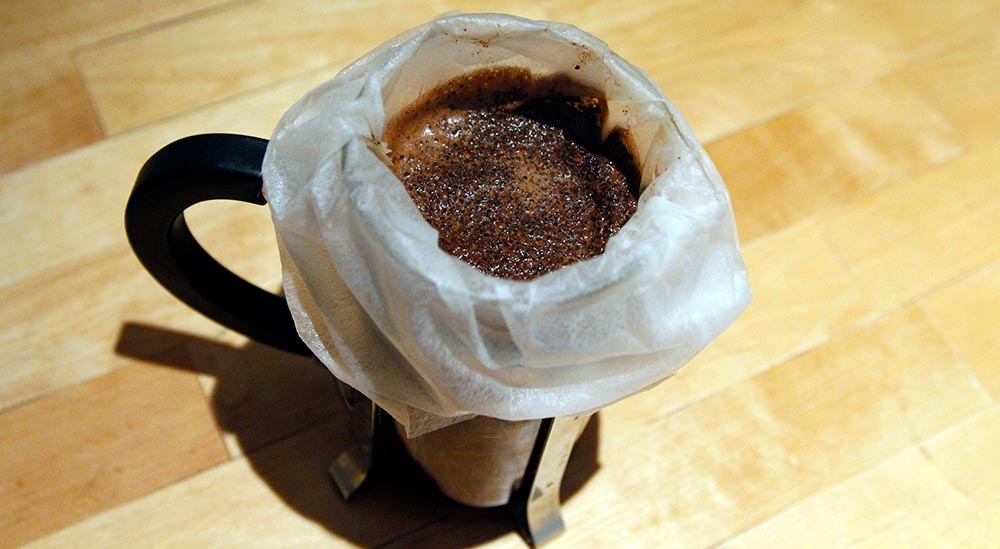 Presskannefilteret er fylt med kaffe og vann.
