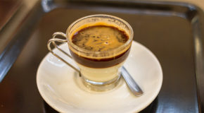 Et glass med kondensert melk nederst og espresso øverst.