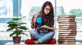 En ung kvinne sitter og leser mens hun drikker kaffe, fordi hun har hørt at man blir smartere av kaffe.
