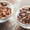 En skål med arabica-bønner og en skål med robusta-bønner står ved siden av hverandre.
