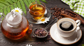 En mugge med te, en kopp med te og en kopp med kaffe står på et bord.