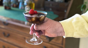 En hånd holder et drinkglass med kaffecocktailen Deja Brew.