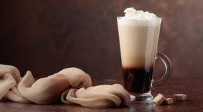 En espresso med krem på toppen er i et glass på et bord – den er en av våre unike kaffedrikker fra hele verden