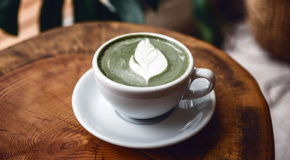 En kopp med matcha-latte står på et bord i en kafé.