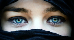 Kun to blå øyne er synlige av en kvinne med sjal.