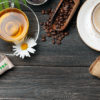 En kopp med grønn te og en kopp med kaffe står ved siden av hverandre på et bord