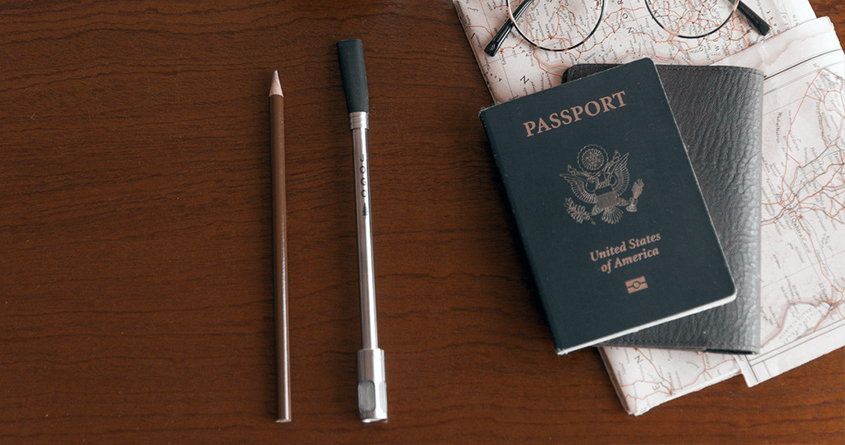 Et JoGo-sugerør ligger på et bord sammen med et pass, et kart, et par briller og en blyant