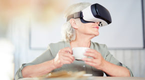 En eldre kvinne drikker kaffe mens hun har på VR-briller