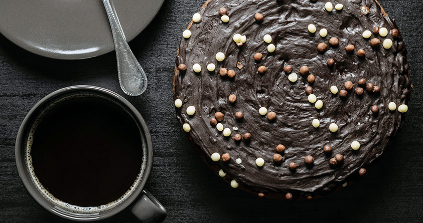 En espressokake står på et bord ved siden av en kopp med kaffe