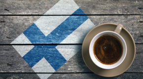 En kaffekopp står foran et finsk flagg
