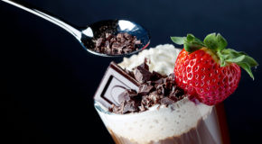 Nærbilde av et glass med kaffe, sjokolade og jordbær