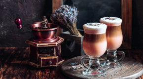 To glass med Raf-kaffe står på et bord sammen med en bukett med lavendel