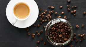 Fugleperspektiv av en espresso og en krukke med kaffebønner