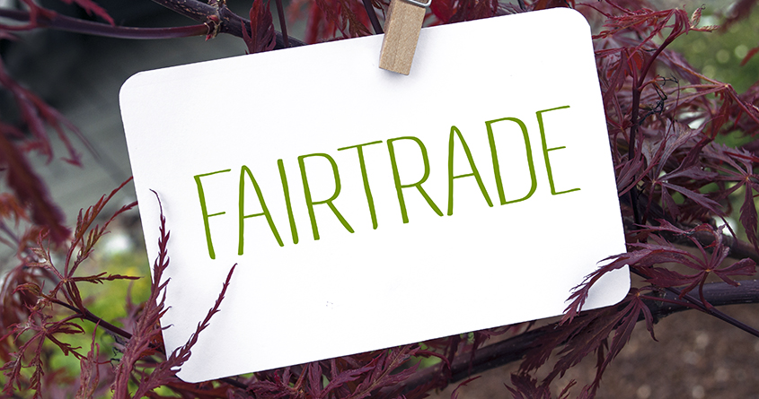 En lapp med "fairtrade" skrevet er hengt opp i en busk med en klesklype