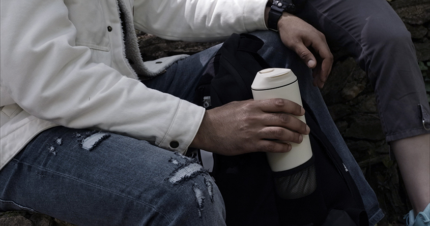 En mann holder en ATONCE kaffebrygger i hånden på tur