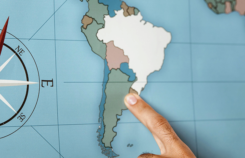 En person peker på et kart over Sør-Amerika