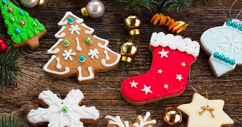 Pyntede pepperkaker ligger på en kjøkkenbenk, blant annet en julestrømpe, juletrær og snøflak