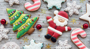 Mange pepperkaker ligger på et bord, blant annet en julenisse, et juletre og mange snøflak