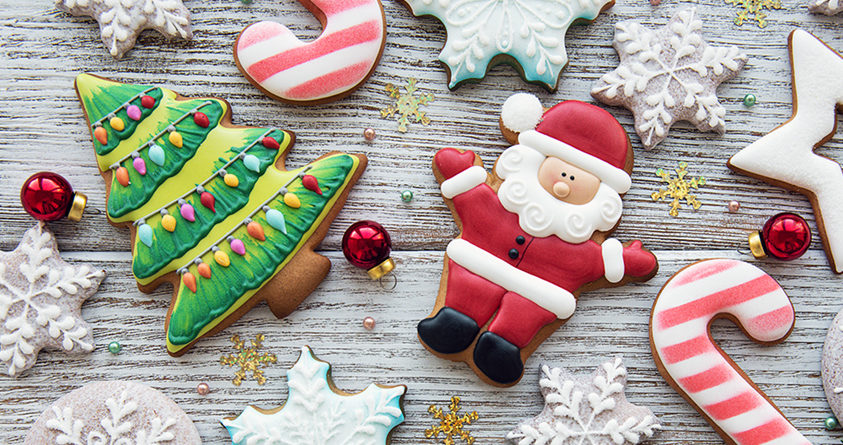 Mange pepperkaker ligger på et bord, blant annet en julenisse, et juletre og mange snøflak