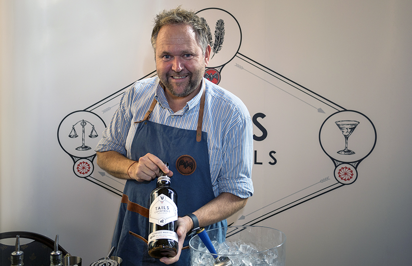 Henning Hjelljord fra Tails Cocktails holder opp en flaske med espresso martini og smiler mot kameraet