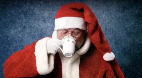Julenissen drikker kaffe fra en julekopp