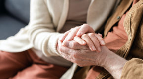 Nærbilde av to eldre personer som holder hender
