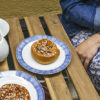 En kvinne sitter på en kafé og nyter kaffe og kanelboller – såkalt fika