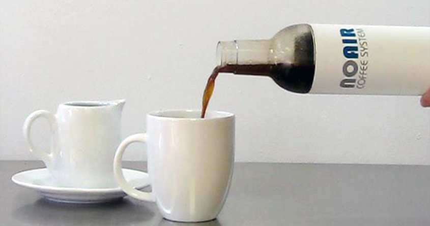 Noen heller ferdig kaffe fra en NoAir-kaffebrygger over i en hvit kopp