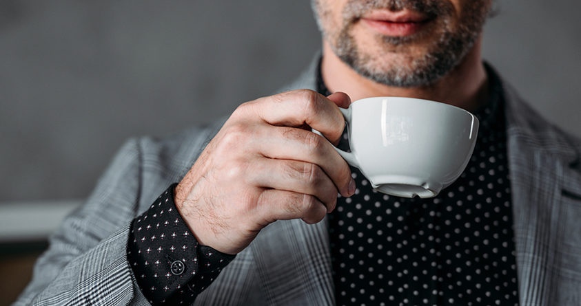 En mann holder en kaffekopp opp mot munnen