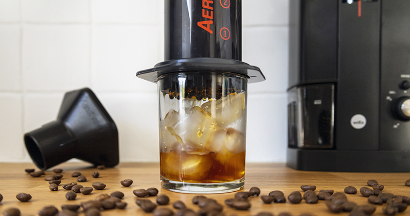 Kaffe presses gjennom en Aeropress og oppi et glass med isbiter