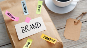 En grå emballasjepose ligger på et bord, med teksten «brand – design – quality – name – logo – identity».