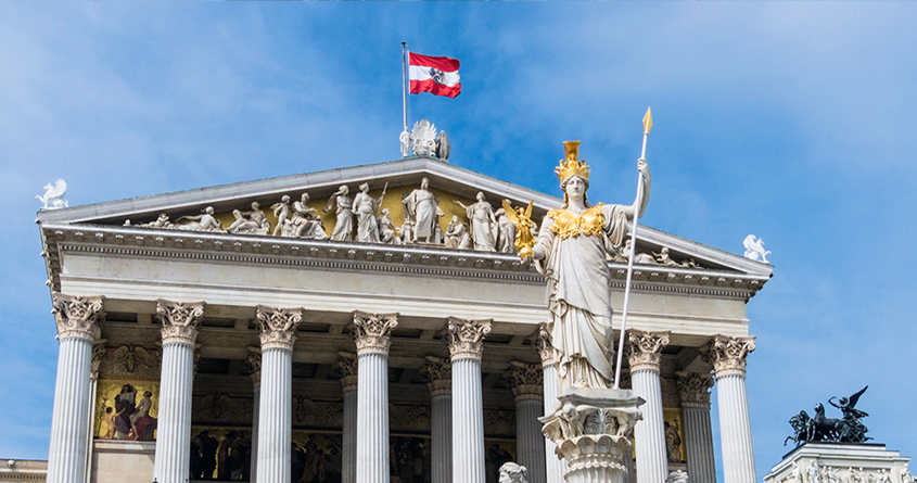 Bilde av parliamentet i Wien med et østerriksk flagg.