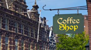 Et skilt hvor det står "coffee shop" henger på en vegg i Amsterdam