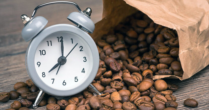 En alarmklokke står oppå en seng med kaffebønner