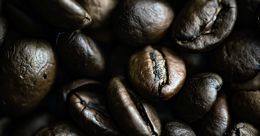 Nærbilde av mørkbrente kaffebønner