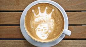 Lattekunst av en dronning er laget i en kopp med kaffe