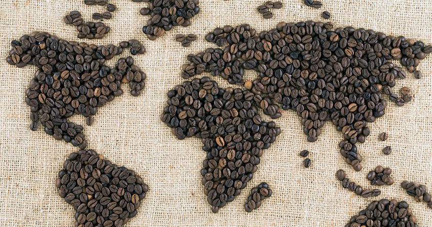 Et verdenskart laget av kaffebønner er lagt på en striesekk