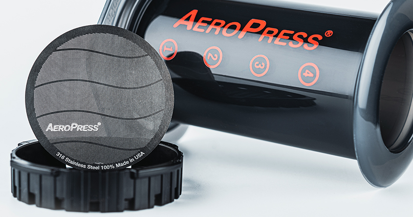 Et AeroPress-metallfilter lener seg mot en AeroPress