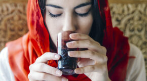 En arabisk kvinne drikker qahwa fra en kopp
