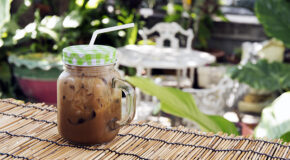 Et glass med thailandsk iskaffe står på et bord