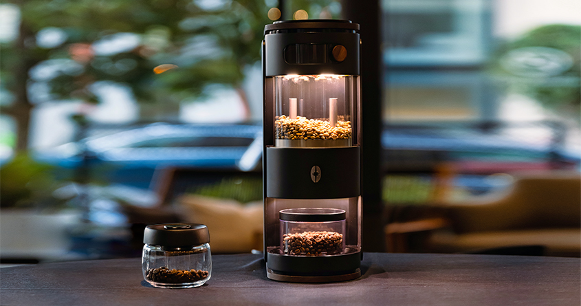 Kaffebrenneren fra Bunafr står på et bord ved siden av en vakuumbeholder med brent kaffe
